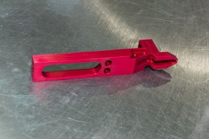 custom-concepts-kickout-arm-1 Red machined kick-out arm for a label printing machine