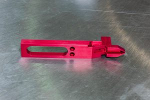 custom-concepts-kickout-arm-2 Red machined kick-out arm for a label printing machine