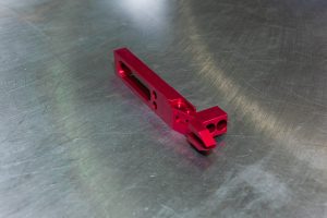custom-concepts-kickout-arm-4 Red machined kick-out arm for a label printing machine