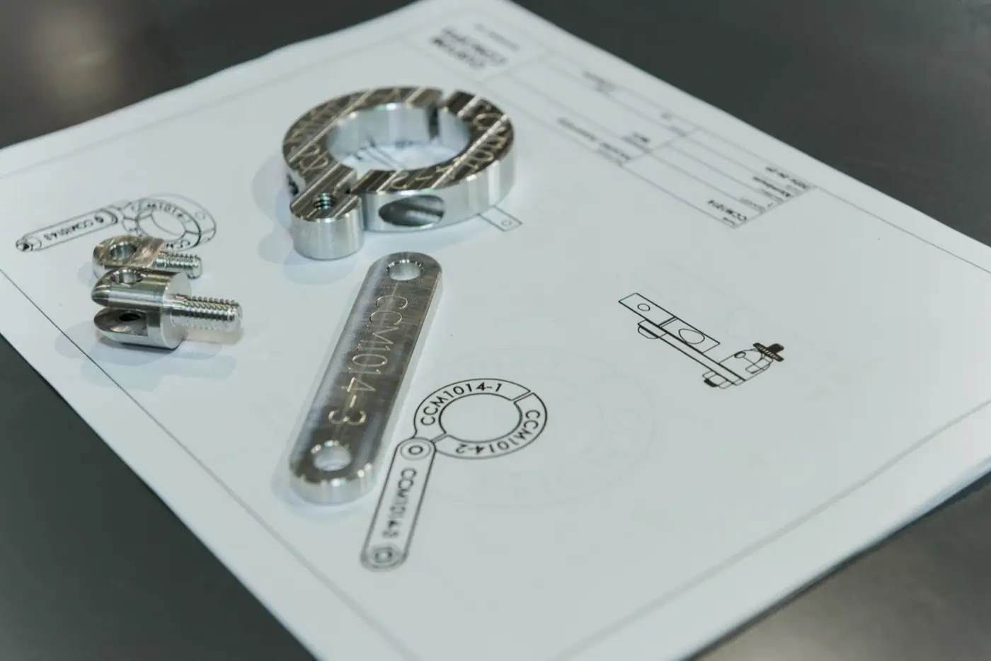 Machined parts next to the CAD model they were made from