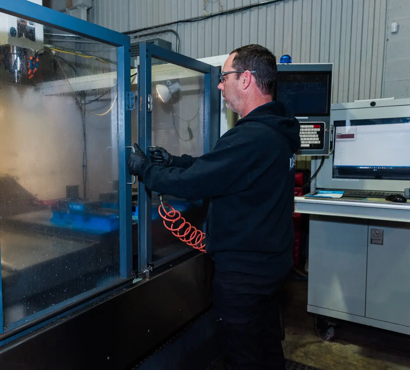 Machinist at a CNC machine at Custom Concepts