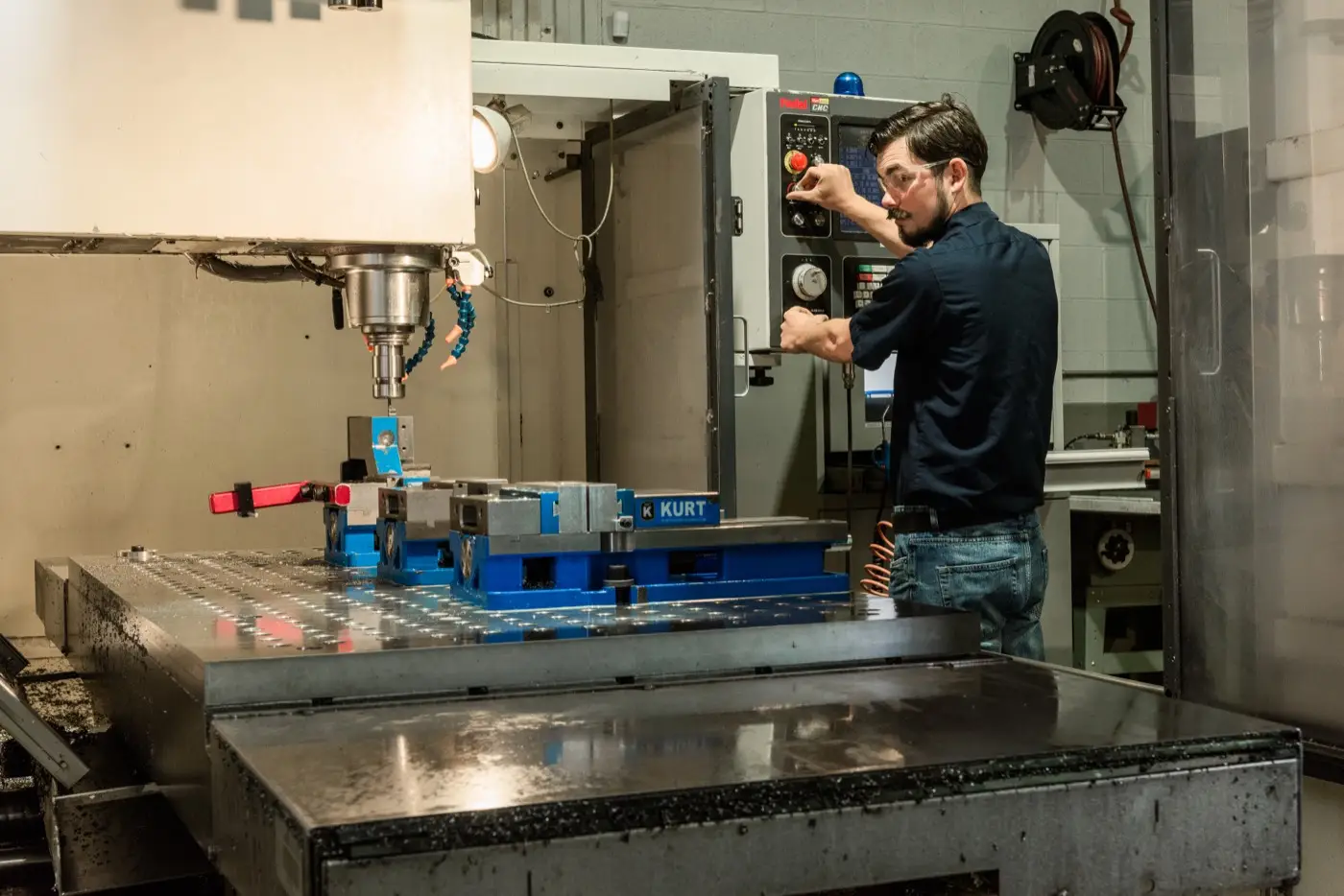 Machinist setting up a part on a CNC machine at Custom Concepts